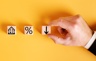 Symbolbild Mietminderung: Würfel mit Pfeil, Haus und Prozentzeichen